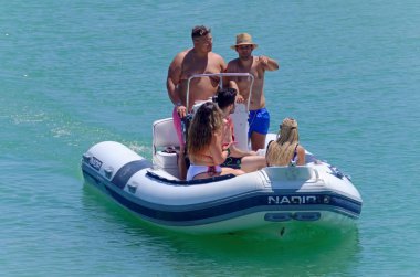 İtalya, Sicilya, Akdeniz, Marina di Ragusa (Ragusa Eyaleti); 26 Temmuz 2020, limandaki kauçuk bir teknede insanlar - EDITORIAL