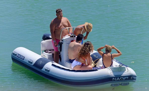 İtalya, Sicilya, Akdeniz, Marina di Ragusa (Ragusa Eyaleti); 26 Temmuz 2020, limandaki kauçuk bir teknede insanlar - EDITORIAL