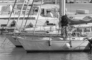 İtalya, Sicilya, Akdeniz, Marina di Ragusa (Ragusa Eyaleti); 26 Temmuz 2020, limandaki bir yelkenli teknesinde adam - EDITORIAL