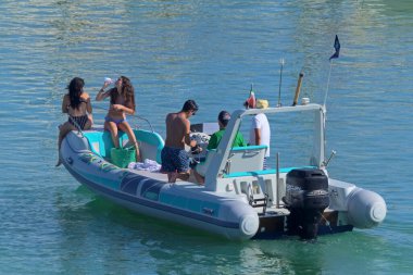 İtalya, Sicilya, Akdeniz, Marina di Ragusa (Ragusa Eyaleti); 26 Temmuz 2020, limandaki kauçuk bir teknede insanlar - EDITORIAL