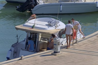 İtalya, Sicilya, Akdeniz, Marina di Ragusa (Ragusa Eyaleti); 27 Temmuz 2020, insanlar limanda lüks bir yatta - EDITORIAL