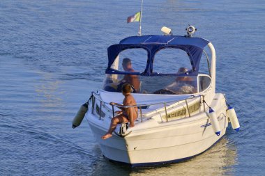 İtalya, Sicilya, Akdeniz, Marina di Ragusa (Ragusa Eyaleti); 30 Temmuz 2020, limanda lüks bir yatta insanlar - EDITORIAL