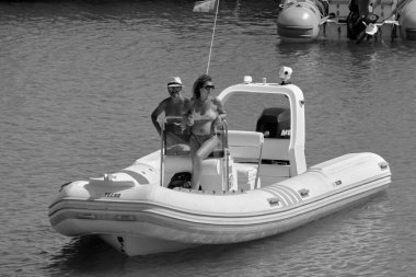 İtalya, Sicilya, Akdeniz, Marina di Ragusa (Ragusa ili); 2 Ağustos 2020, limanda bir kauçuk teknede çift - EDITORIAL