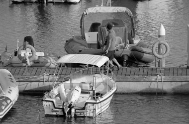 İtalya, Sicilya, Akdeniz, Marina di Ragusa (Ragusa ili); 17 Ağustos 2020, limanda insanlar ve motorlu tekneler - EDITORIAL