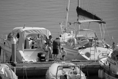 İtalya, Sicilya, Akdeniz, Marina di Ragusa (Ragusa ili); 19 Ağustos 2020, limandaki insanlar, motorlu tekneler ve lüks yatlar - EDITORIAL