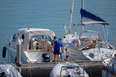 İtalya, Sicilya, Akdeniz, Marina di Ragusa (Ragusa ili); 19 Ağustos 2020, limandaki insanlar, motorlu tekneler ve lüks yatlar - EDITORIAL