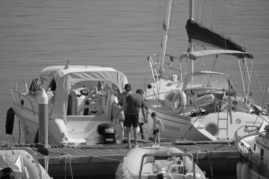 İtalya, Sicilya, Akdeniz, Marina di Ragusa (Ragusa ili); 19 Ağustos 2020, limandaki insanlar, motorlu tekneler ve lüks yatlar - EDITORIAL