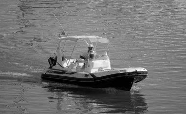 İtalya, Sicilya, Akdeniz, Marina di Ragusa (Ragusa Eyaleti); 19 Ağustos 2020, limandaki kauçuk bir teknede adam - EDITORIAL