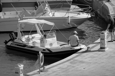 İtalya, Sicilya, Akdeniz, Marina di Ragusa (Ragusa Eyaleti); 19 Ağustos 2020, limandaki kauçuk bir tekne ve lüks yatlarda adam - EDITORIAL