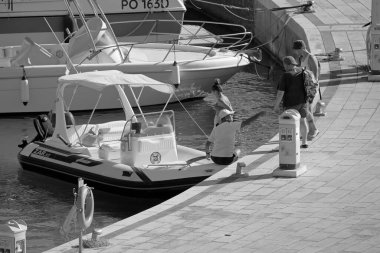 İtalya, Sicilya, Akdeniz, Marina di Ragusa (Ragusa Eyaleti); 19 çirkin 2020, limandaki kauçuk tekne ve lüks yatlarda yaşayan insanlar - EDITORIAL
