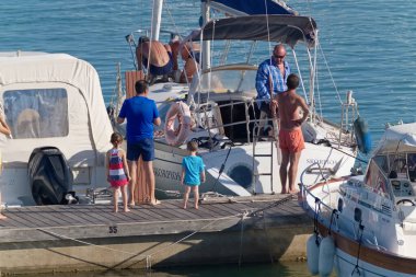 İtalya, Sicilya, Akdeniz, Marina di Ragusa (Ragusa Eyaleti); 20 Ağustos 2020, limandaki insanlar ve lüks yatlar - EDITORIAL