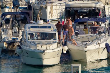 İtalya, Sicilya, Akdeniz, Marina di Ragusa (Ragusa Eyaleti); 20 Ağustos 2020, limandaki lüks yatlarda yaşayan insanlar - EDITORIAL