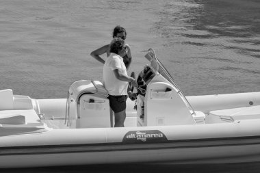 İtalya, Sicilya, Akdeniz, Marina di Ragusa (Ragusa ili); 22 Ağustos 2020, limanda bir kauçuk teknede çift - EDITORIAL