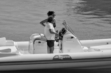 İtalya, Sicilya, Akdeniz, Marina di Ragusa (Ragusa ili); 22 Ağustos 2020, limanda bir kauçuk teknede çift - EDITORIAL