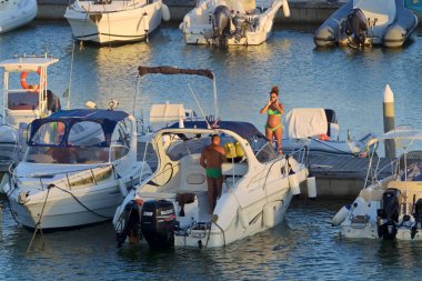 İtalya, Sicilya, Akdeniz, Marina di Ragusa (Ragusa ili); 27 Ağustos 2020, limanda lüks bir yatta çift - EDITORIAL