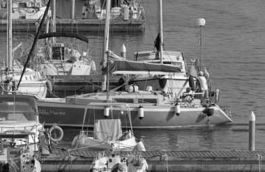 İtalya, Sicilya, Akdeniz, Marina di Ragusa (Ragusa Eyaleti); 30 Ağustos 2020, limanda bir yelkenli teknesi ve lüks yatlarda bir çift - EDITORIAL