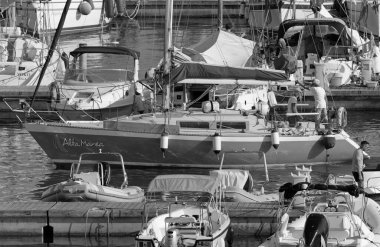 İtalya, Sicilya, Akdeniz, Marina di Ragusa (Ragusa Eyaleti); 30 Ağustos 2020, limanda bir yelkenli teknesi ve lüks yatlarda bir çift - EDITORIAL