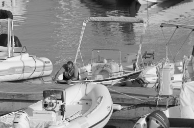 İtalya, Sicilya, Akdeniz, Marina di Ragusa (Ragusa Eyaleti); 30 Ağustos 2020, limandaki bir motorlu teknede adam - EDITORIAL
