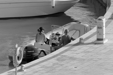 İtalya, Sicilya, Akdeniz, Marina di Ragusa (Ragusa ili); 31 Ağustos 2020, limanda bir kauçuk teknede çift - EDITORIAL