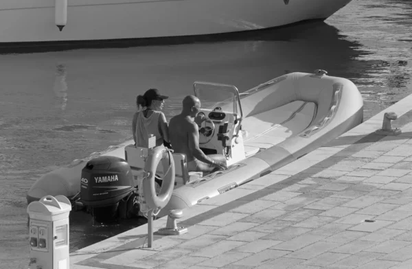 İtalya, Sicilya, Akdeniz, Marina di Ragusa (Ragusa ili); 31 Ağustos 2020, limanda bir kauçuk teknede çift - EDITORIAL