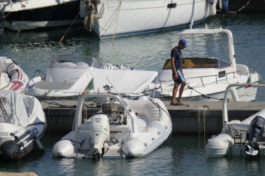 İtalya, Sicilya, Akdeniz, Marina di Ragusa (Ragusa Eyaleti); 1 Eylül 2020, limandaki insanlar, motorlu tekneler ve lüks yatlar - EDITORIAL