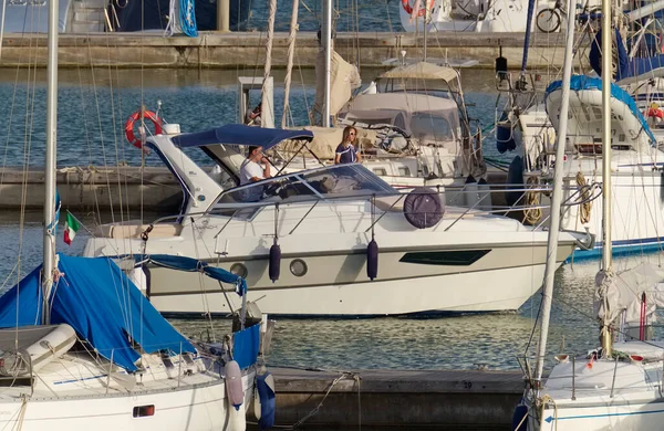 İtalya, Sicilya, Akdeniz, Marina di Ragusa (Ragusa Eyaleti); 2 Eylül 2020, limanda lüks bir yatta çift - EDITORIAL