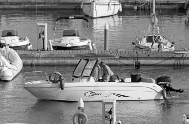 İtalya, Sicilya, Akdeniz, Marina di Ragusa (Ragusa ili); 5 Eylül 2020, limandaki bir motorlu tekne ve lüks yatlarda yaşayan insanlar - EDITORIAL