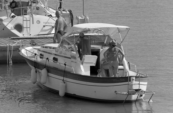 İtalya, Sicilya, Akdeniz, Marina di Ragusa (Ragusa Eyaleti); 6 Eylül 2020, limanda lüks bir yatta insanlar - EDITORIAL