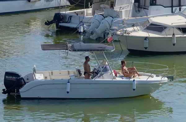 İtalya, Sicilya, Akdeniz, Marina di Ragusa (Ragusa Eyaleti); 6 Eylül 2020, limanda bir motorlu tekne ve lüks yatlarda bir çift - EDITORIAL