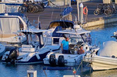 İtalya, Sicilya, Akdeniz, Marina di Ragusa (Ragusa ili); 11 Eylül 2020, limandaki bir motorlu tekne ve lüks yatlarda yaşayan insanlar - EDITORIAL