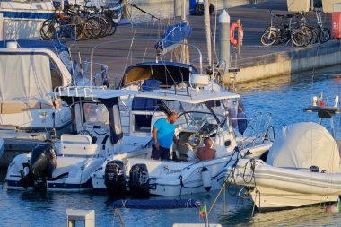 İtalya, Sicilya, Akdeniz, Marina di Ragusa (Ragusa ili); 11 Eylül 2020, limandaki bir motorlu tekne ve lüks yatlarda yaşayan insanlar - EDITORIAL