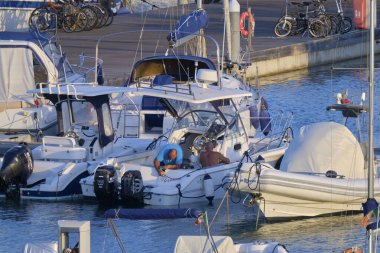 İtalya, Sicilya, Akdeniz, Marina di Ragusa (Ragusa ili); 11 Eylül 2020, limandaki bir motorlu tekne ve lüks yatlarda yaşayan insanlar - EDITORIAL