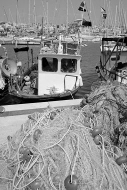 İtalya, Sicilya, Marina di Ragusa (Ragusa Eyaleti), Sicilya tahtadan balıkçı tekneleri, balıkçı ağları ve limanda lüks yatlar 