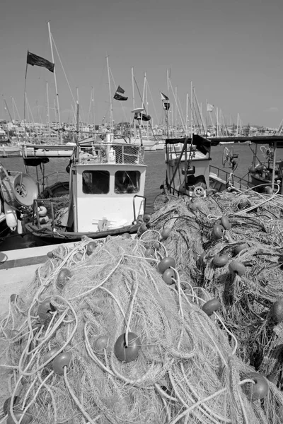 İtalya, Sicilya, Marina di Ragusa (Ragusa Eyaleti), Sicilya tahtadan balıkçı tekneleri, balıkçı ağları ve limanda lüks yatlar 