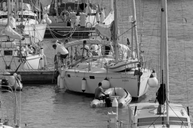 İtalya, Sicilya, Akdeniz, Marina di Ragusa (Ragusa Eyaleti); 3 Ekim 2020, limandaki bir yelkenli teknesinde insanlar - EDITORIAL