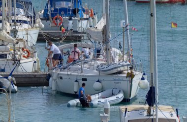 İtalya, Sicilya, Akdeniz, Marina di Ragusa (Ragusa Eyaleti); 3 Ekim 2020, limandaki bir yelkenli teknesinde insanlar - EDITORIAL