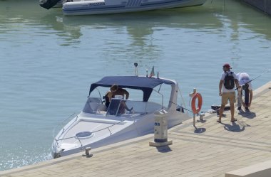 İtalya, Sicilya, Akdeniz, Marina di Ragusa (Ragusa Eyaleti); 10 Ekim 2020, limanda lüks bir yatta insanlar - EDITORIAL