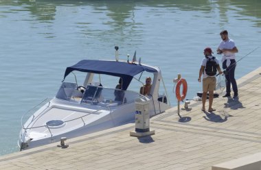 İtalya, Sicilya, Akdeniz, Marina di Ragusa (Ragusa Eyaleti); 10 Ekim 2020, limanda lüks bir yatta insanlar - EDITORIAL