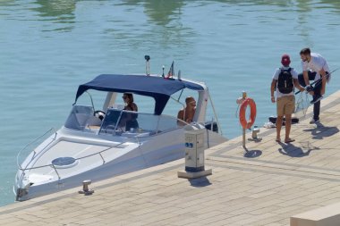 İtalya, Sicilya, Akdeniz, Marina di Ragusa (Ragusa Eyaleti); 10 Ekim 2020, limanda lüks bir yatta insanlar - EDITORIAL