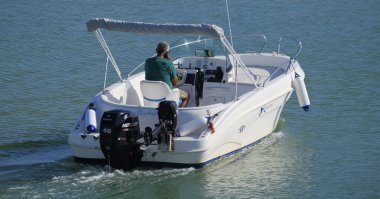 İtalya, Sicilya, Akdeniz, Marina di Ragusa (Ragusa Eyaleti); 4 Eylül 2025, limandaki bir motorlu teknede adam - EDITORIAL