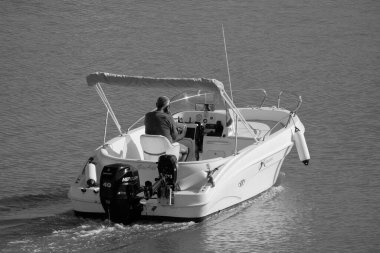 İtalya, Sicilya, Akdeniz, Marina di Ragusa (Ragusa Eyaleti); 4 Eylül 2025, limandaki bir motorlu teknede adam - EDITORIAL