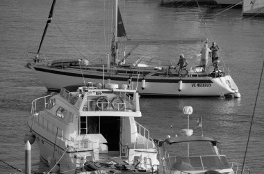 Italy, Sicily, Mediterranean Sea, Marina di Ragusa (Ragusa Province); 4 September 2025, people on a sailing boat and luxury yachts in the port - EDITORIAL