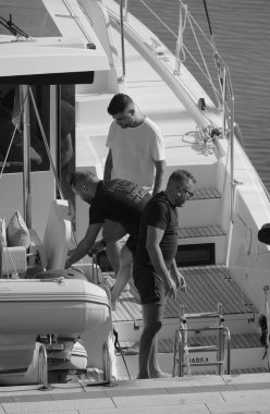 İtalya, Sicilya, Akdeniz, Marina di Ragusa (Ragusa Eyaleti); 13 Eylül 2025, limandaki bir katamaran yelkenli teknesinde erkekler - EDITORIAL