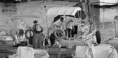 İtalya, Sicilya, Akdeniz, Marina di Ragusa (Ragusa Eyaleti); 13 Eylül 2025, limandaki bir yelkenli teknesinde insanlar - EDITORIAL