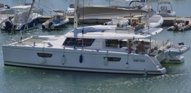 İtalya, Sicilya, Akdeniz, Marina di Ragusa (Ragusa Eyaleti); 14 Eylül 2025, limandaki katamaran yelkenli teknesinde insanlar - EDITORIAL