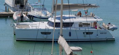 İtalya, Sicilya, Akdeniz, Marina di Ragusa (Ragusa Eyaleti); 14 Eylül 2025, limandaki katamaran yelkenli teknesinde insanlar - EDITORIAL