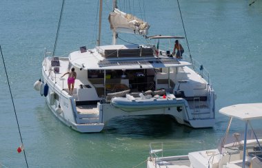 İtalya, Sicilya, Akdeniz, Marina di Ragusa (Ragusa Eyaleti); 14 Eylül 2025, limandaki katamaran yelkenli teknesinde insanlar - EDITORIAL