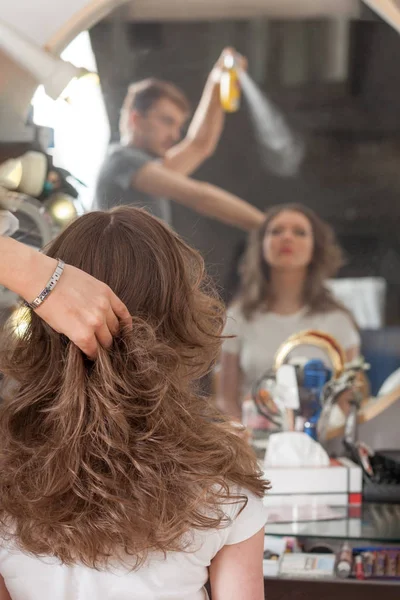 Professional hairdresser with long hair model. Professional hair care.