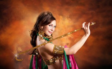 Geleneksel bellydance bir kostümle renkli stüdyo arka plan üzerinde dans muhteşem bir kadın bellydancer.