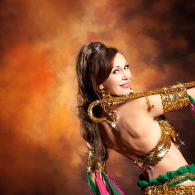 Geleneksel bellydance bir kostümle renkli stüdyo arka plan üzerinde dans muhteşem bir kadın bellydancer.
